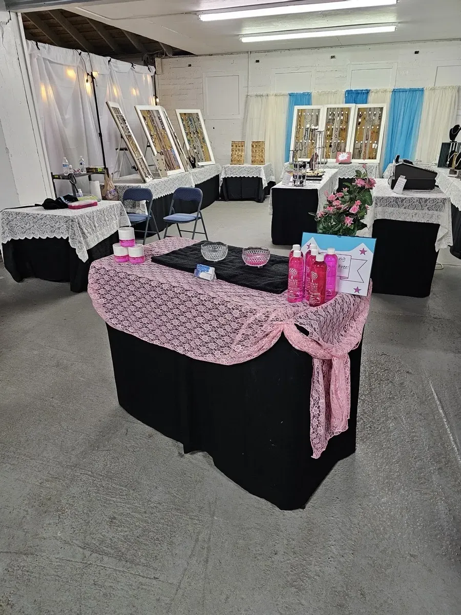 Indoor craft show booth with pink and black display